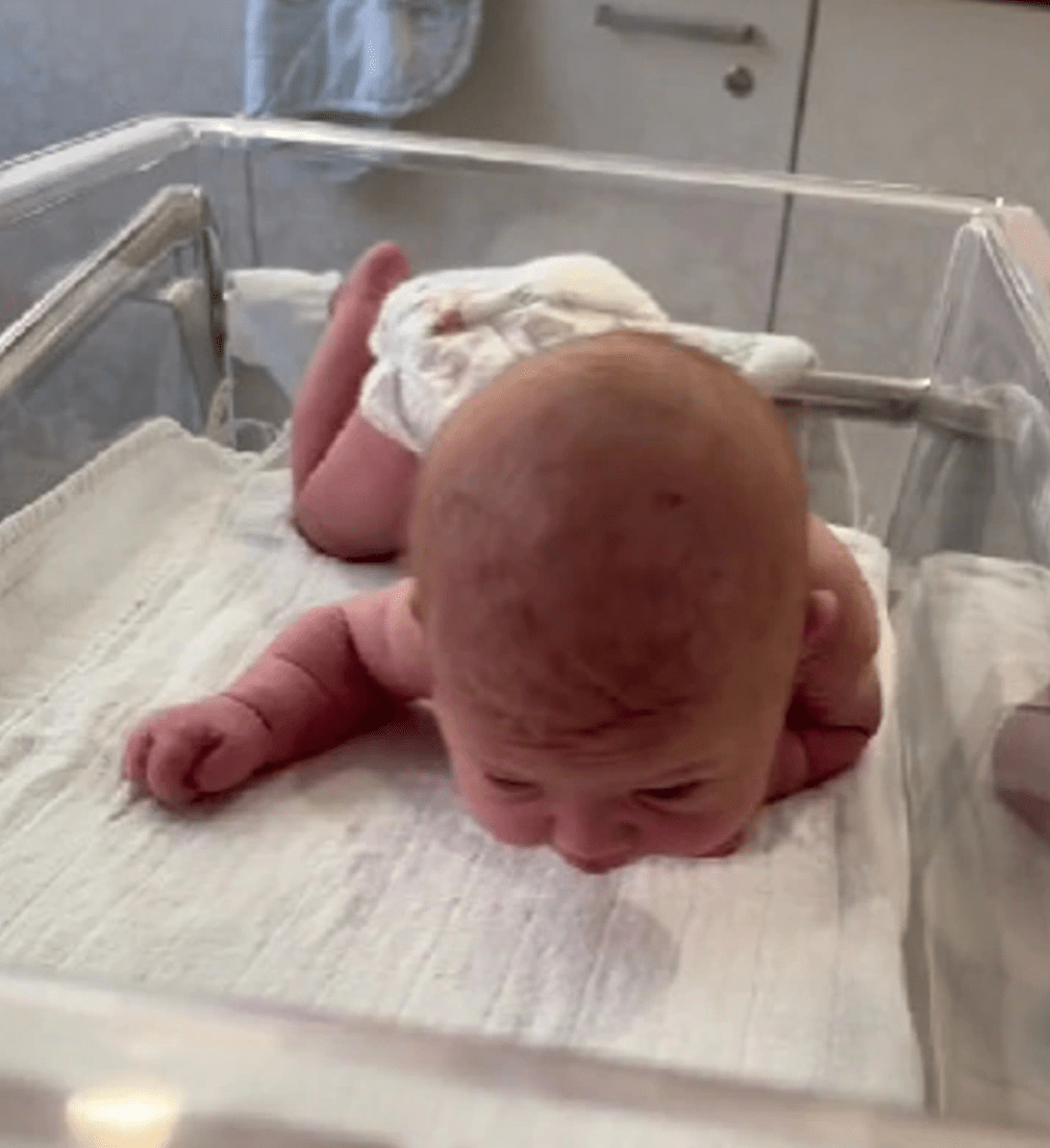 A newborn baby who is three days old CRAWS, raises its head, and begins to speak.